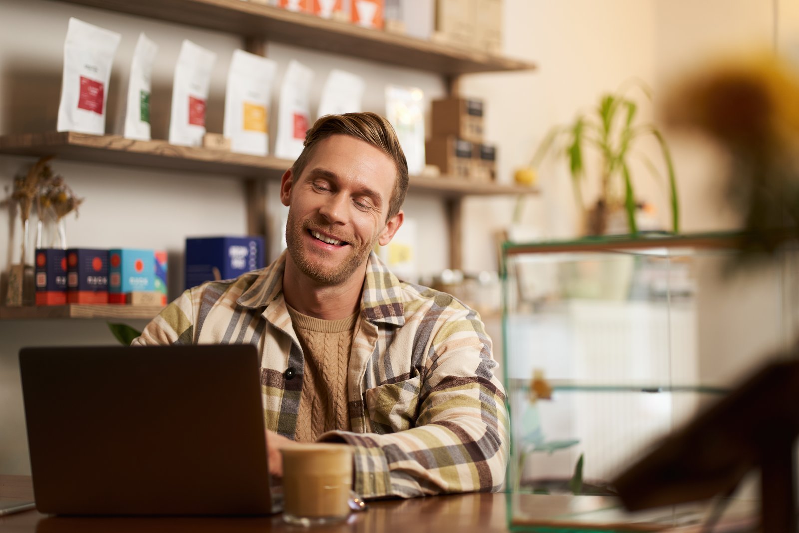 Młody freelancer pracuje na laptopie w kawiarni