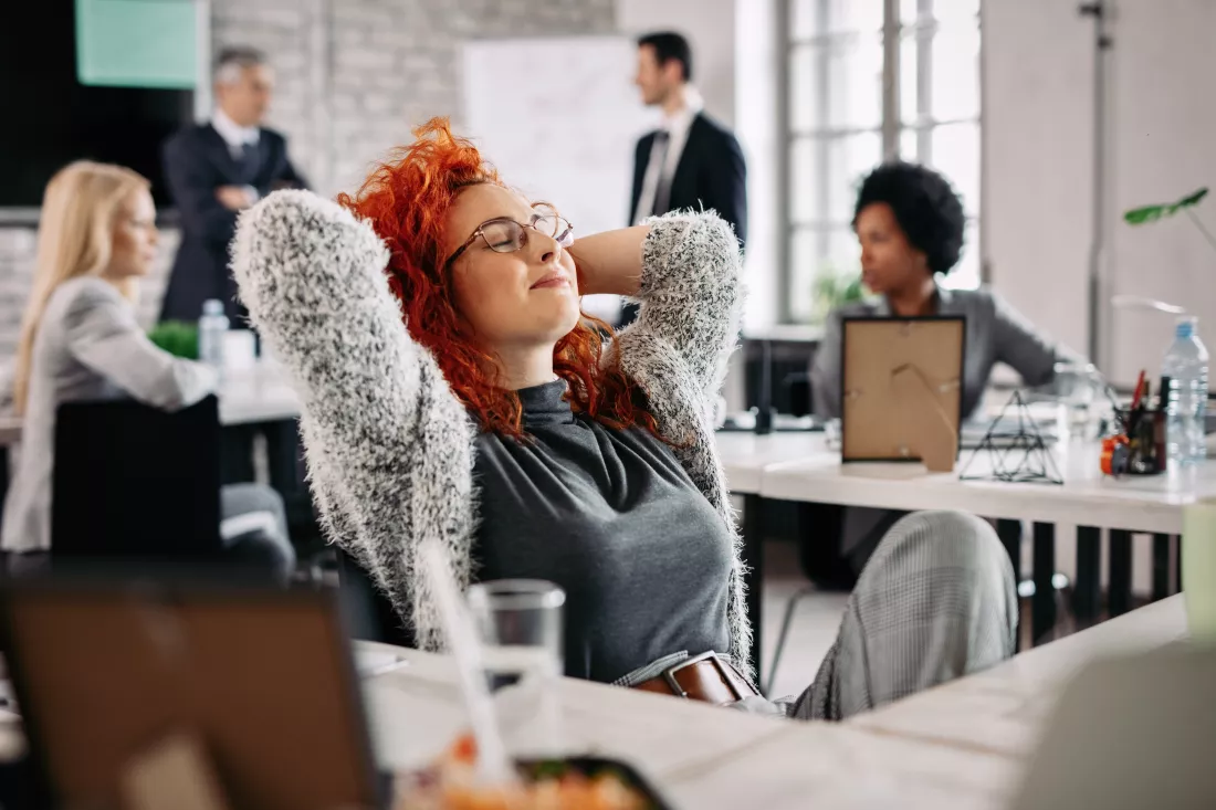 young-creative-businesswoman-with-hands-head-taking-break-resting-with-eyes-closed-office